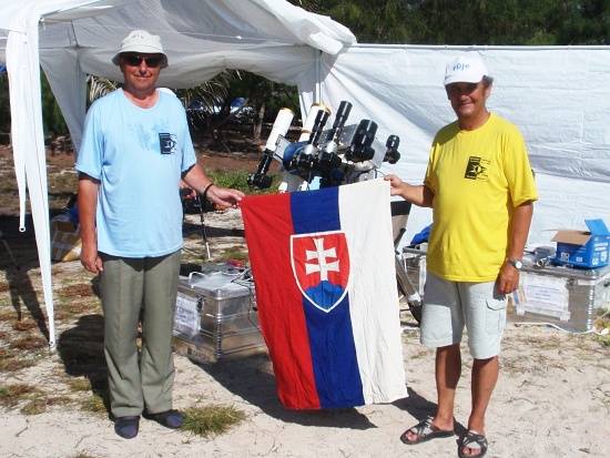 Slovenská vlajka na atole Enewetak v rukách dvoch vedeckých pracovníkov zo Slovenskej akadémie vied - astronóma Vojtecha Rušina (vľavo) a Ľubomíra Klocoka. 