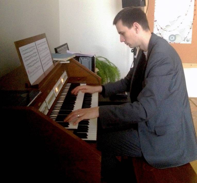 Martin Bako hrá na organe v zasadacej miestnosti ÚNPF SAV