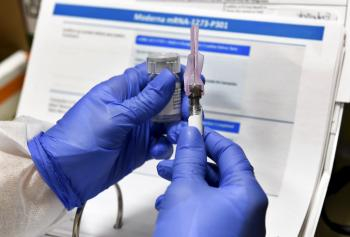 Zdravotná sestra drží experimentálnu vakcínu na ochorenie COVID-19, ktorú vyvinula biotechnologická firma Moderna
