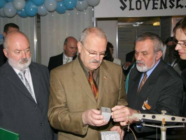 Prezident Ivan Gašparovič (druhý zľava) s kockou z penového hliníka. Na preváženie jednej 350 g kocky z plného hliníka  treba 8 rovnako veľkých kociek z penového hliníka. Vľavo Ľubomír Falťan, celkom vpravo (v okuliaroch) Roman Florek z Ústavu materiálov a mechaniky strojov SAV a Svetozár Balkovic z ÚACH SAV (druhý zprava).